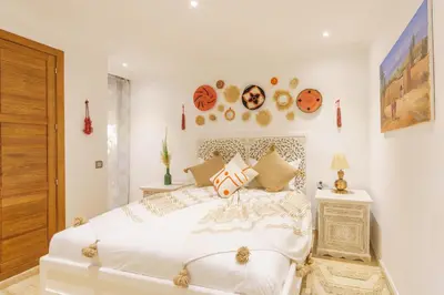 a bedroom with a white bed with pillows on it at Luxueux 138 m2 avec piscine in Marrakech