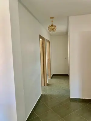 an empty hallway with white walls and a chandelier at Belle Appartement familiale,couple marié in Marrakech
