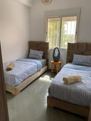 a bedroom with two beds and a window at Belle Appartement familiale,couple marié in Marrakech