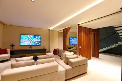 a living room with a large couch and a television at Duplex de luxe, piscine sauna in Marrakech