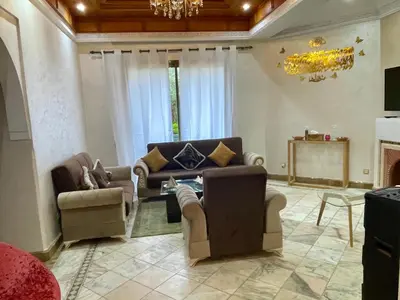 a living room with couches and a chandelier at Au Riad de la Palmeraie - Marrakech in Marrakech