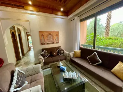a living room with couches and a large window at Au Riad de la Palmeraie - Marrakech in Marrakech