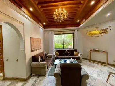 a living room with couches and a chandelier at Au Riad de la Palmeraie - Marrakech in Marrakech