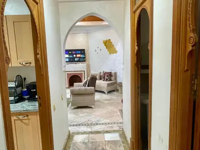 a living room with an archway and a room with a fireplace at Au Riad de la Palmeraie - Marrakech in Marrakech