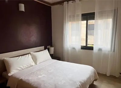 a bedroom with a white bed and a window at Luminous apartment with pool view in Marrakech