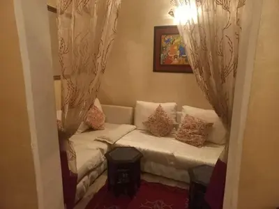 a living room with a white couch with pillows at Riad Lahbiba in Marrakech