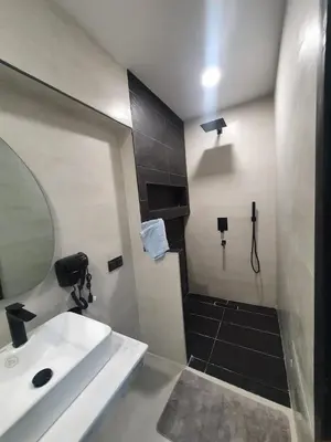a bathroom with a sink and a shower with a mirror at Kech vacations Friendly 2 Bedroom Luxury apartment in Marrakech