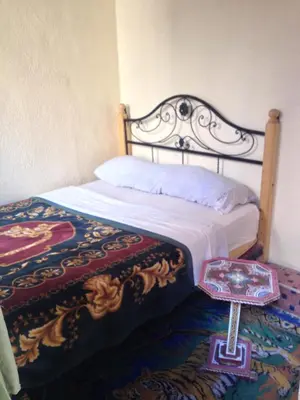 a bed in a room with a cross on the floor at Riad Espagne in Marrakech