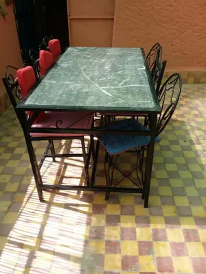 a table and chairs with a green table and chairs at Riad Espagne in Marrakech