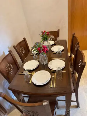 a wooden table with plates and flowers on it at Bel appartement à louer à Marrakech targa in Marrakech