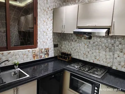 a kitchen with white cabinets and a stove top oven at Luxury villa near airport & City center in Marrakech
