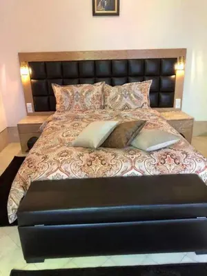a large bed with a black leather headboard and pillows at Riad Dar Rania Marrakech Médina Jemaa El Fna in Marrakech