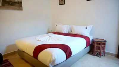 a bedroom with a large bed with white sheets at RIAD KALE POLIS in Marrakech
