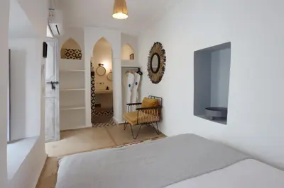a bedroom with a bed and a chair in it at Riad Pop, a haven in the heart of the Medina in Marrakech