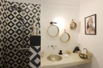a bathroom with a sink and mirrors on the wall at Riad Pop, a haven in the heart of the Medina in Marrakech