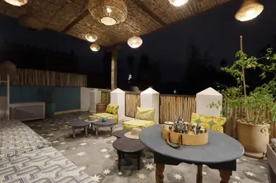 a patio with a table and chairs and lights at Riad Pop, a haven in the heart of the Medina in Marrakech