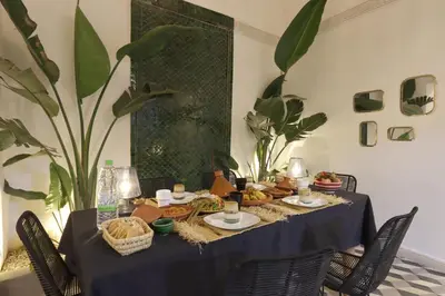 a table with a blue table cloth with food on it at Riad Pop, a haven in the heart of the Medina in Marrakech
