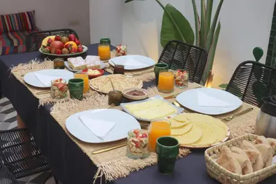 a table topped with plates of food and fruit at Riad Pop, a haven in the heart of the Medina in Marrakech