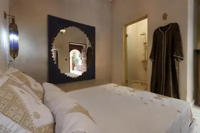 a bedroom with a white bed and a mirror at Riad La Fayette Bed & Breakfast in Marrakech