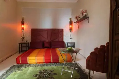a bedroom with a colorful bed and a table at Riad La Fayette Bed & Breakfast in Marrakech