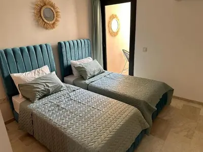 a bedroom with two beds and a mirror at Charm Apartment in Marrakech in Marrakech