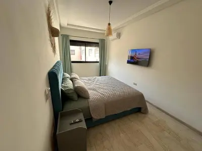 a bedroom with a bed in a room with a window at Charm Apartment in Marrakech in Marrakech