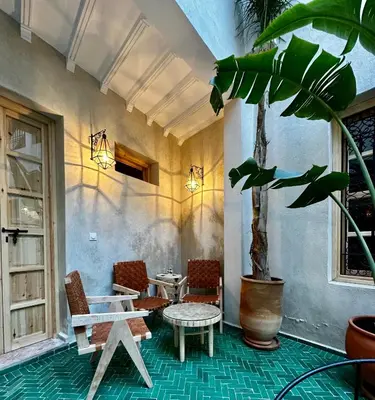 a patio with a table and chairs and a plant at Riad Citrus By La Siredrah in Marrakech