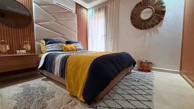 a bedroom with a bed and a mirror and a rug at LA FINCA DE MARRAKECH in Marrakech