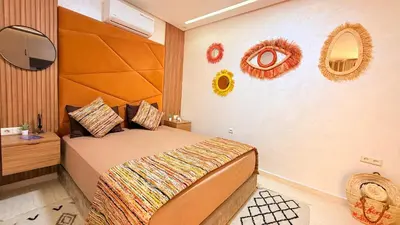 a bedroom with a bed with a large wooden headboard at LA FINCA DE MARRAKECH in Marrakech