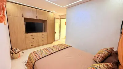 a bedroom with a bed and a flat screen tv at LA FINCA DE MARRAKECH in Marrakech