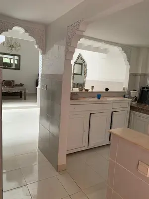 a white kitchen with a sink and a mirror at Riad lalla aicha in Marrakech