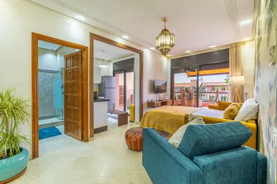 a bedroom with a bed and a couch and a chair at Le Jasmin - Appartement Authentique à Gueliz in Marrakech