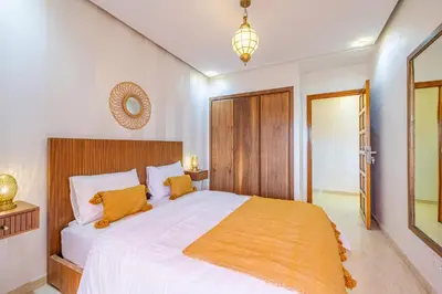a bedroom with a large white bed with orange pillows at Le Jasmin - Appartement Authentique à Gueliz in Marrakech