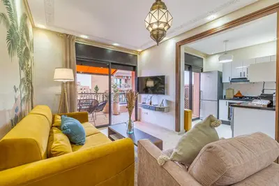 a living room with a yellow couch and a kitchen at L'Atlas - Appartement Authentique à Gueliz in Marrakech