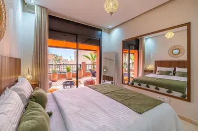 a bedroom with a large bed and a large mirror at L'Atlas - Appartement Authentique à Gueliz in Marrakech