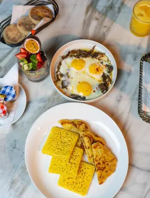 a table with two plates of eggs and toast at Hotel Le Rocher Marrakech in Marrakech