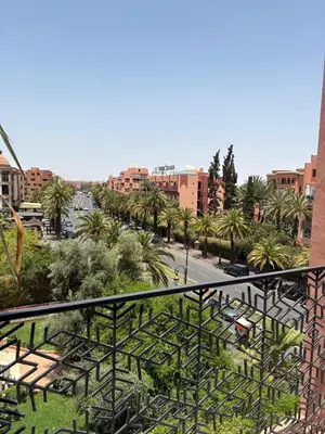 a view of a city with palm trees and buildings at Hotel Le Rocher Marrakech in Marrakech