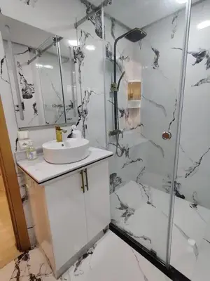 a white bathroom with a sink and a shower at Modern-elegant Appartement in het centrum in Marrakech