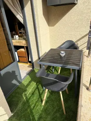 a table and a chair sitting on the grass at Modern-elegant Appartement in het centrum in Marrakech