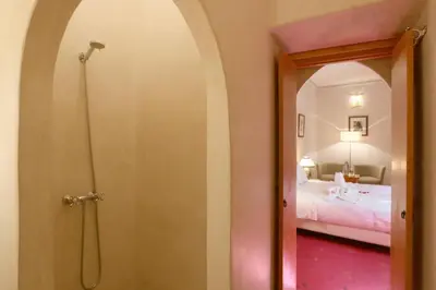 a bathroom with a walk in shower next to a bed at Riad Anais Marrakech in Marrakech