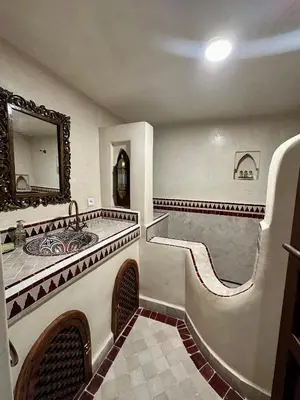 a bathroom with a tub and a sink and a mirror at Riad Sakura Marrakech in Marrakech