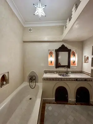 a bathroom with a bath tub and a fireplace at Riad Sakura Marrakech in Marrakech