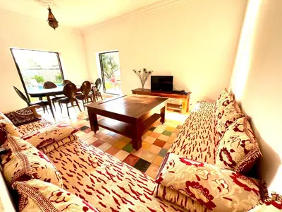 a living room with a couch and a table at Le Domaine des Oliviers in Marrakech