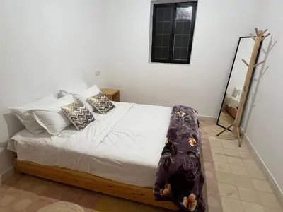 a bedroom with a bed with white sheets and pillows at Le Domaine des Oliviers in Marrakech