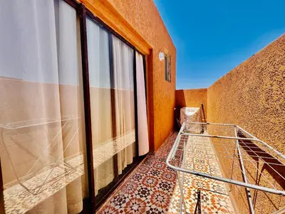 a balcony of a building with a shopping cart at Famille Hanae appartement avec terasse in Marrakech