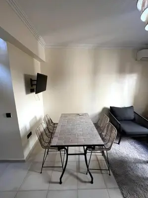 a room with a table and chairs and a couch at NS 36 by Majestic Properties in Marrakech