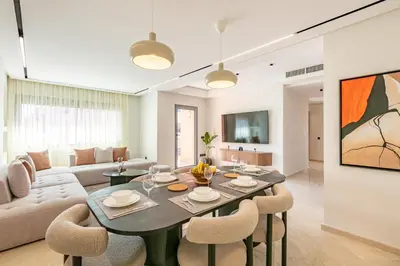 a dining room and living room with a table and chairs at Bohemian Flat in Marrakech