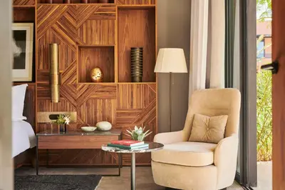 a bedroom with a bed and a chair and a table at Park Hyatt Marrakech in Marrakech