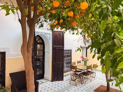 an orange tree in a courtyard with a door at Riad Amethyste in Marrakech