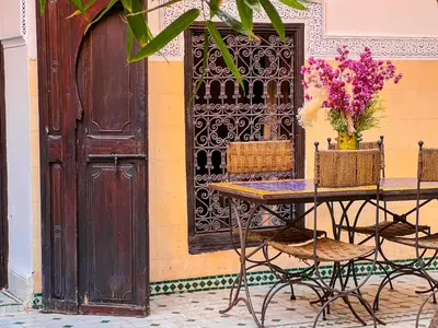 a table and chairs in front of a building at Riad Amethyste in Marrakech